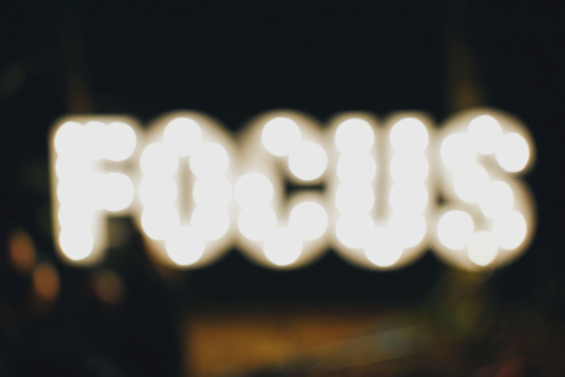 A neon sign that says 'focus' that is out of focus